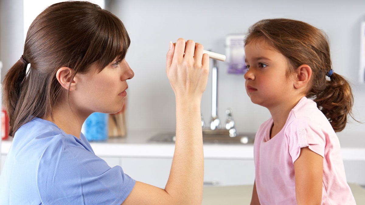 Doctor Examining Child's Eyes In Doctor's Office