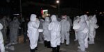 Thumbnail of Personal protective equipment worn by government workers assigned to cull poultry at a wet market in Huzhou city, Zhejiang Province, China, April 8, 2013. The protective clothing included ordinary disposable masks and latex gloves but not goggles or face shields.
