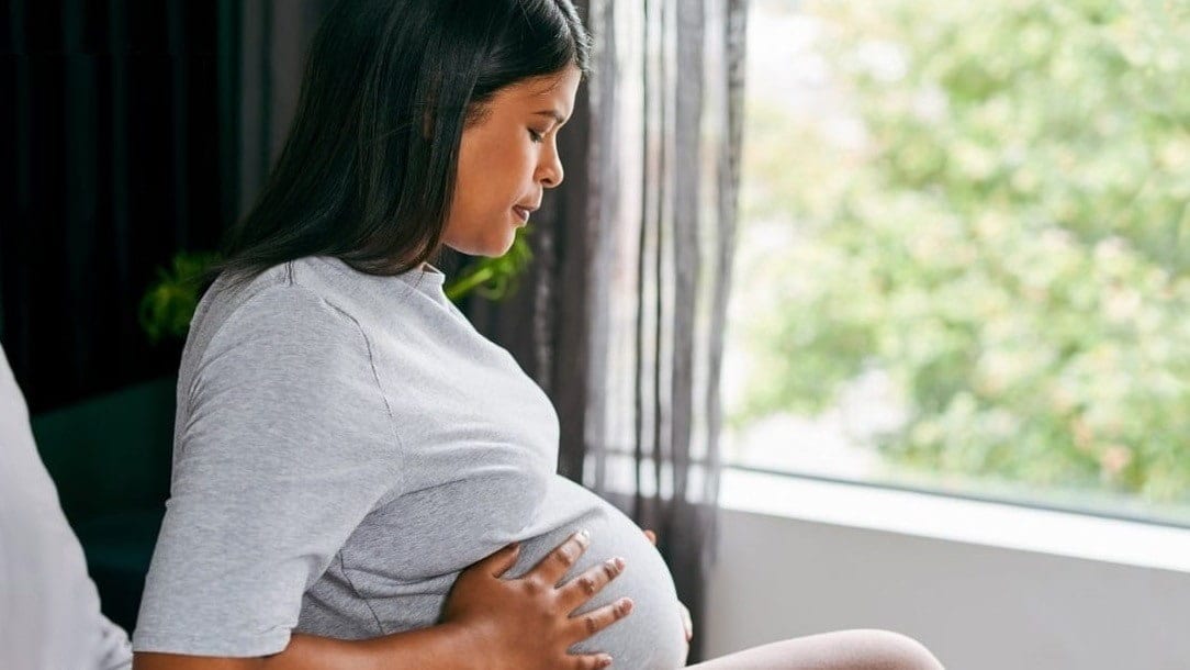 pregnant woman sitting by window