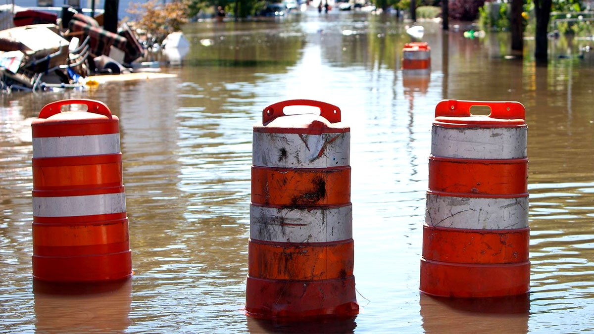 Orange barrels blocking a flooded road