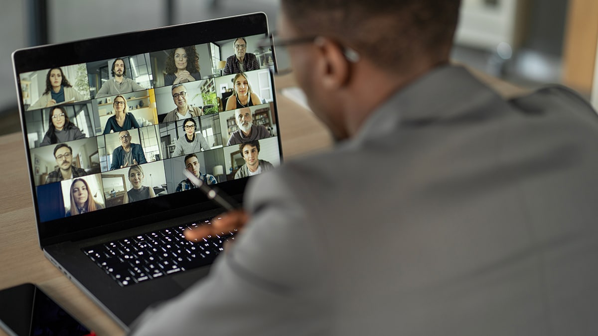 Black man sitting in front of a laptop on a video conference call