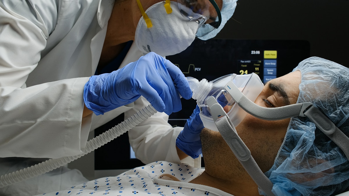 Photo of a healthcare worker adjusting a patient’s ventilator