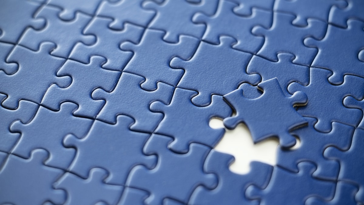 Blue jigsaw puzzle with one piece missing.
