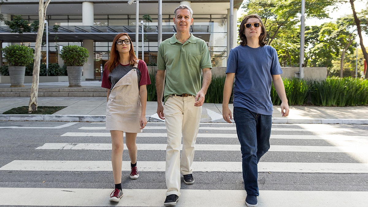 Parent and their two teens walking in a crosswalk.