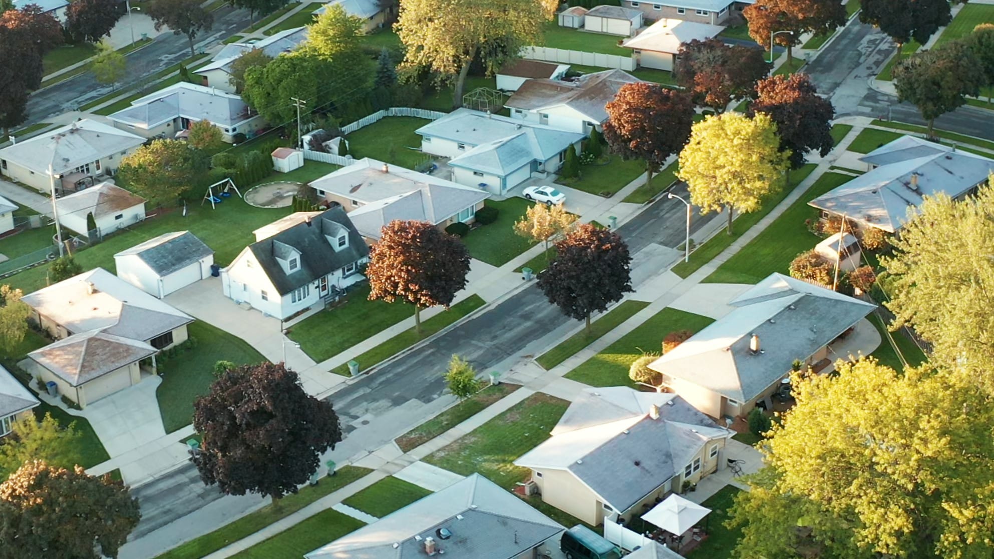 An aerial view of a neighborhood surrounded by green trees.