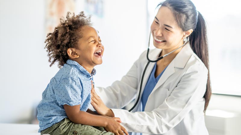 Doctor checking child's heartbeat