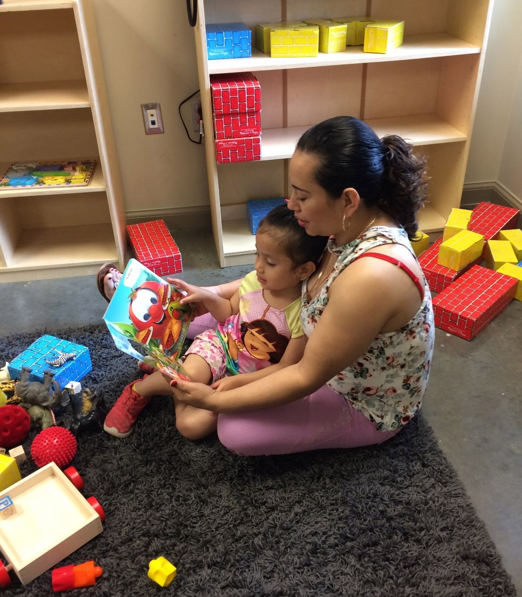 A Legacy mother reading to her child during mother-child time.