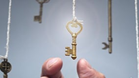 Someone grabbing a key on a white string that has a golden aura to it.