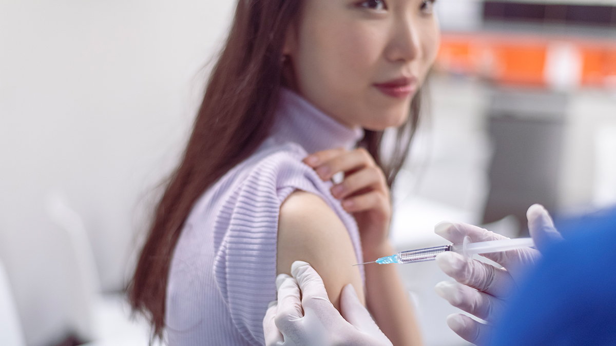 A doctor placing a vaccine in a patient's shoulder