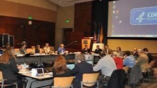 People gathered in a room for a CDC meeting.