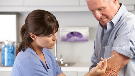 Man getting a vaccination shot in his arm.