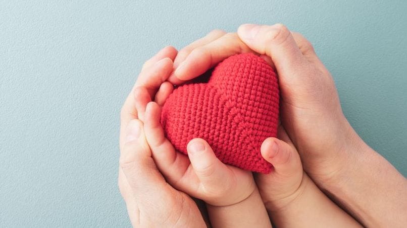 Hands holding a crochet heart