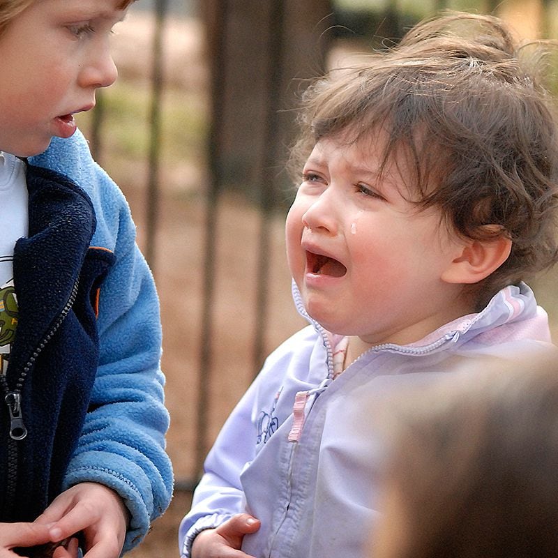 Una niña llora en el patio de juegos.