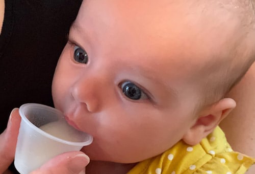 Pour the formula into a disposable cup to feed your baby