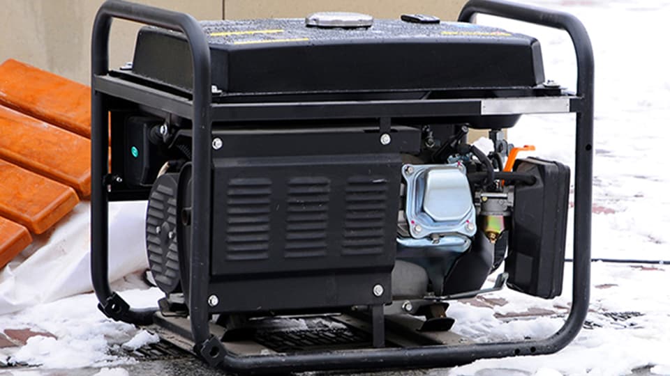 A power generator outside in the snow.