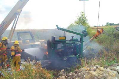 Photo 2 – Second view of firefighters at the scene, showing the portable hydraulic power unit and the suspended.
