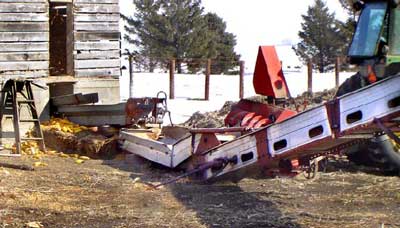 Photo 1 – Overview photograph of the area, showing the east end of the corn crib, the chain drag conveyor, and the flight elevator with half of the PTO driveshaft attached.