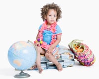 Photo: Una niña con una maleta y un globo terráqueo