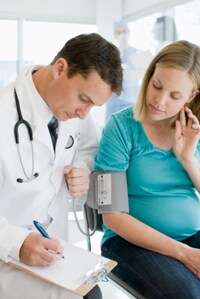 Doctor que toma notas con una mujer embarazada