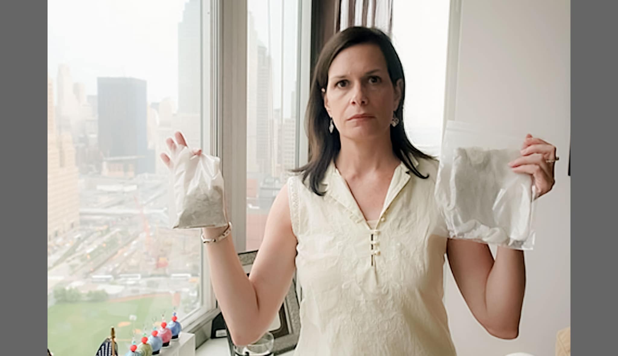 Woman holding a baggie of dust from her apartment and the cheesecloth she used to filter her air conditioner.