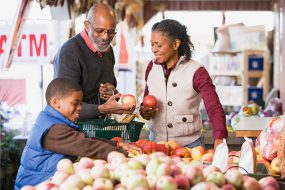 Grandparents and their grandson choosing apples--healthy food concept