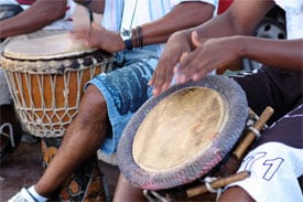 A group of people playing natural hide drums.