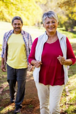 Anciano hombre y mujer afroamericana caminando en el parque