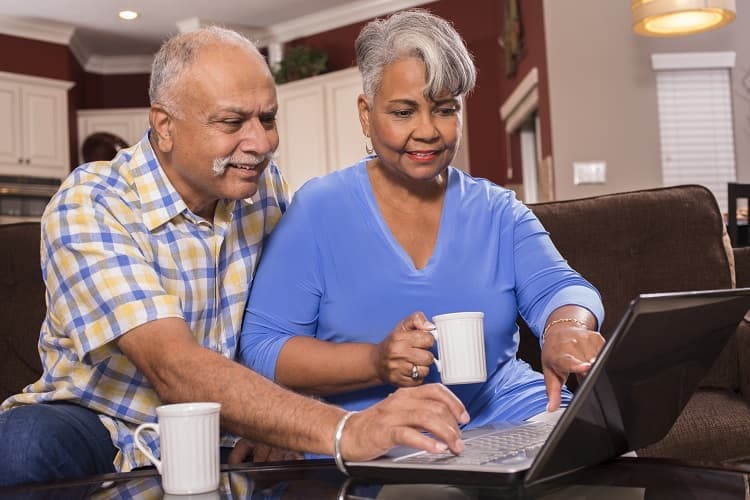 Foto de un hombre y una mujer mirando una computadora portátil