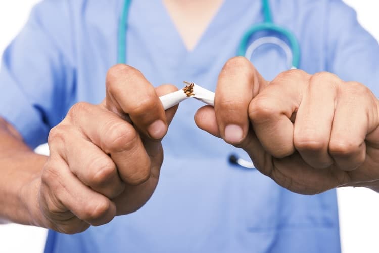 Foto de un doctor rompiendo un cigarrillo