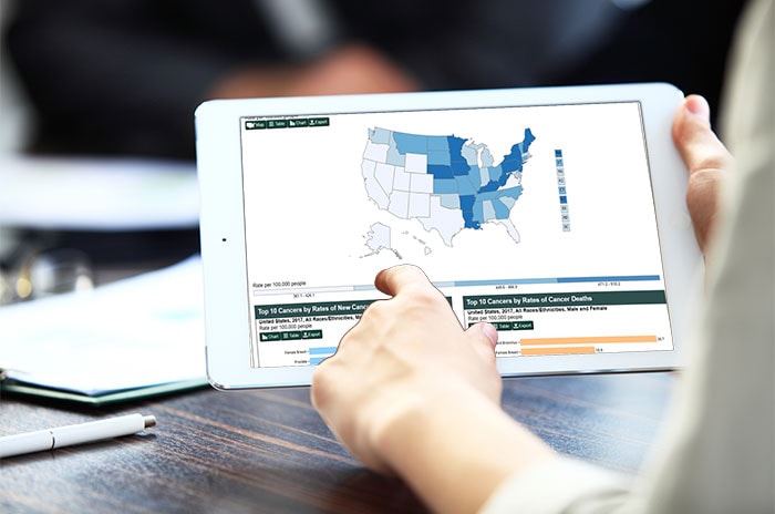 Foto de una persona mirando la herramienta de visualización de datos de las Estadísticas del Cáncer de los EE. UU. web en una tableta