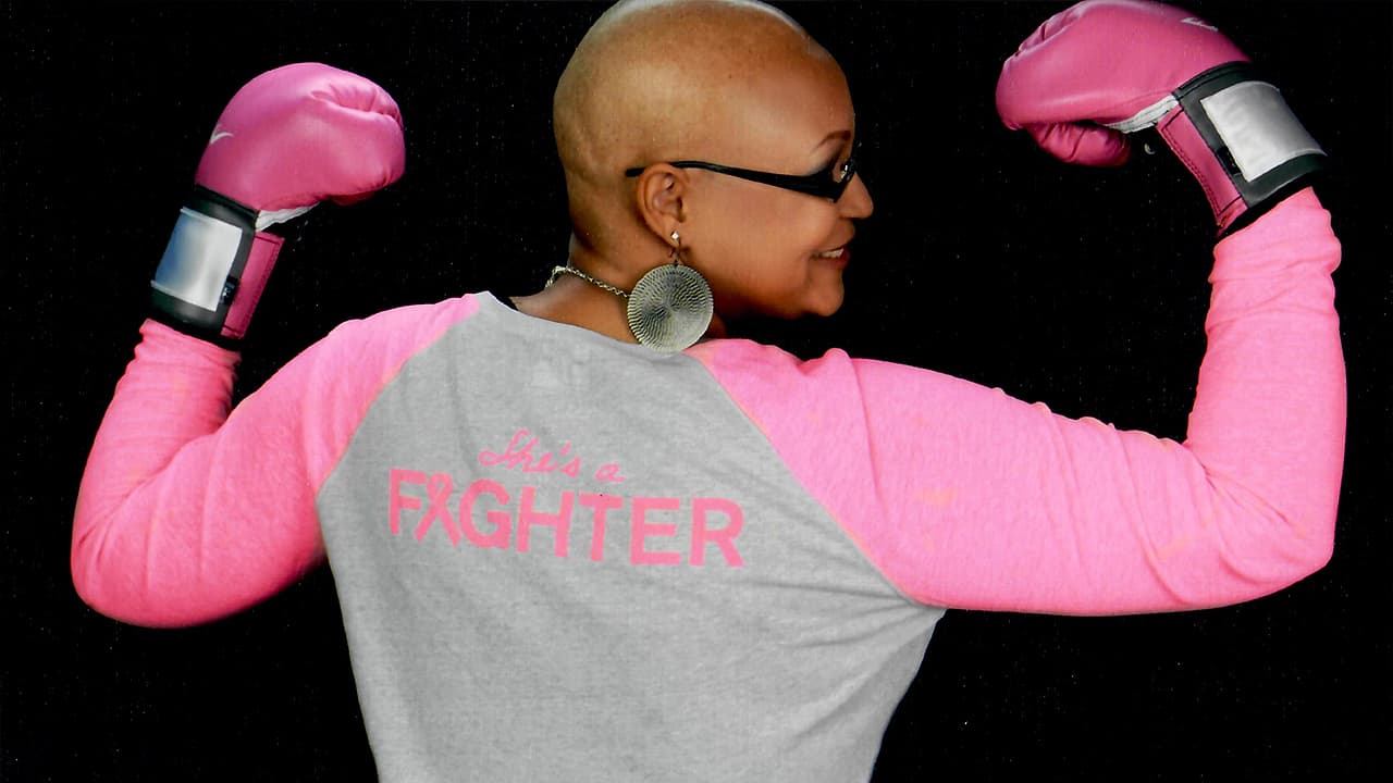 Carletta wearing a shirt that says "She's a Fighter" and punching gloves.