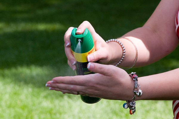 Person spraying bug repellant on the hand.