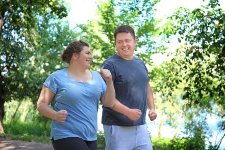 Overweight couple running in a park