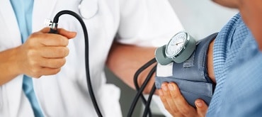 nurse using blood pressure cuff on patient