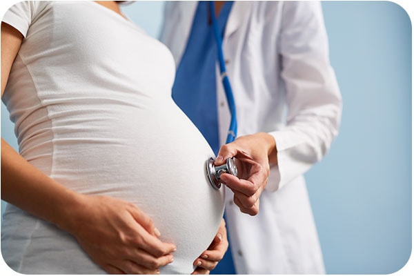 Una mujer embarazada siendo examinada por su médico