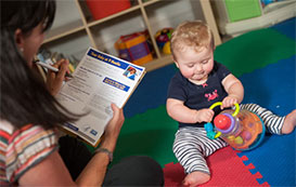 Mother evaluating toddler playing with toys
