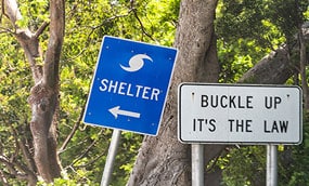 A road sign with an arrow pointing the way to a hurricane shelter