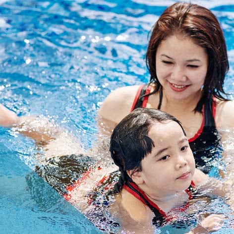 Image of a woman teaching a child to swim