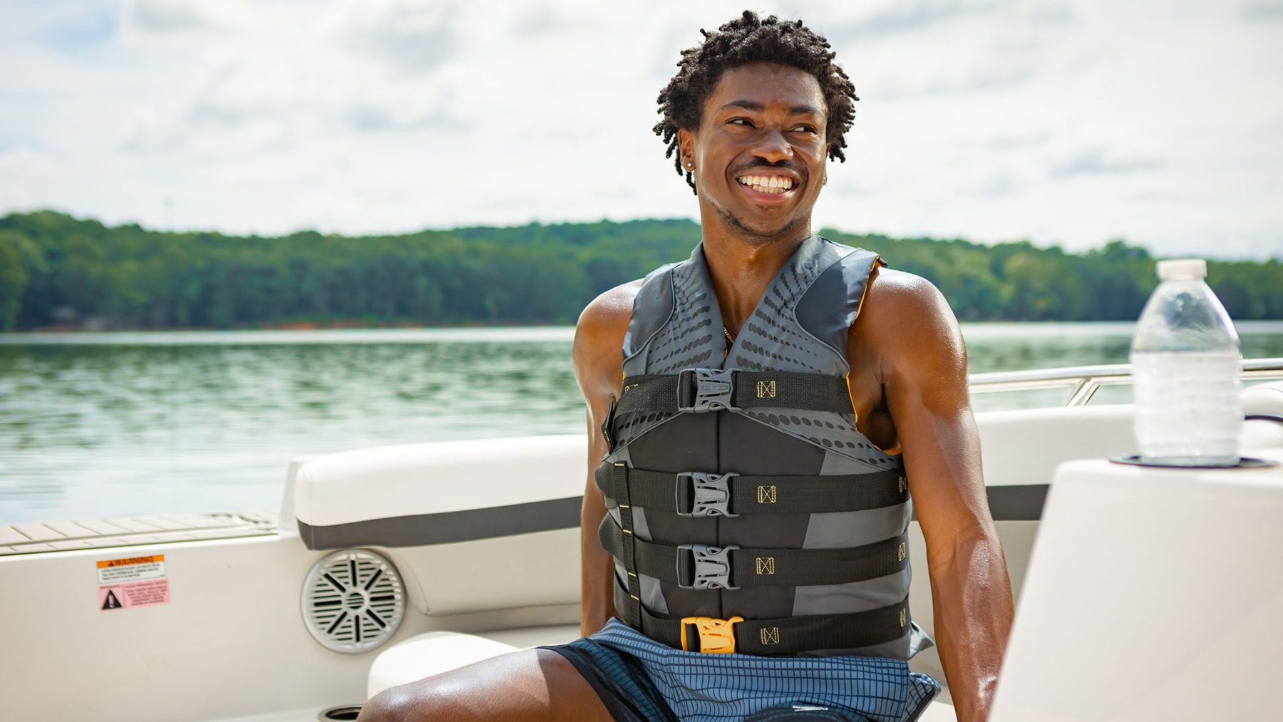 Young Black man on boat wearing a life jacket.