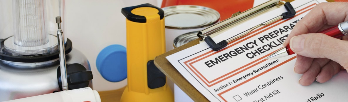 emergency preparedness checklist next to emergency supplies including flashlight, lantern, cans