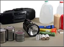 Foto de suministros: linterna, pilas, agua, velas, fósforos, comida enlatada y radio