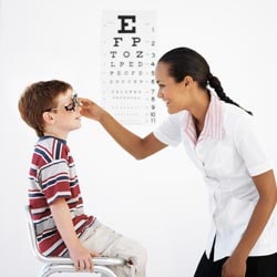 Optometrist giving young boy an exam