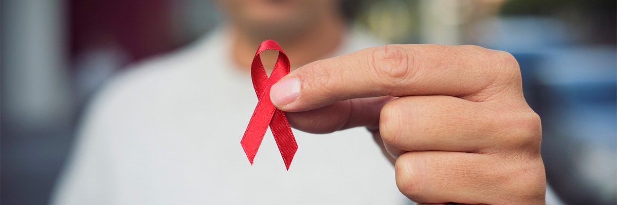 Man with red ribbon for the fight against AIDS