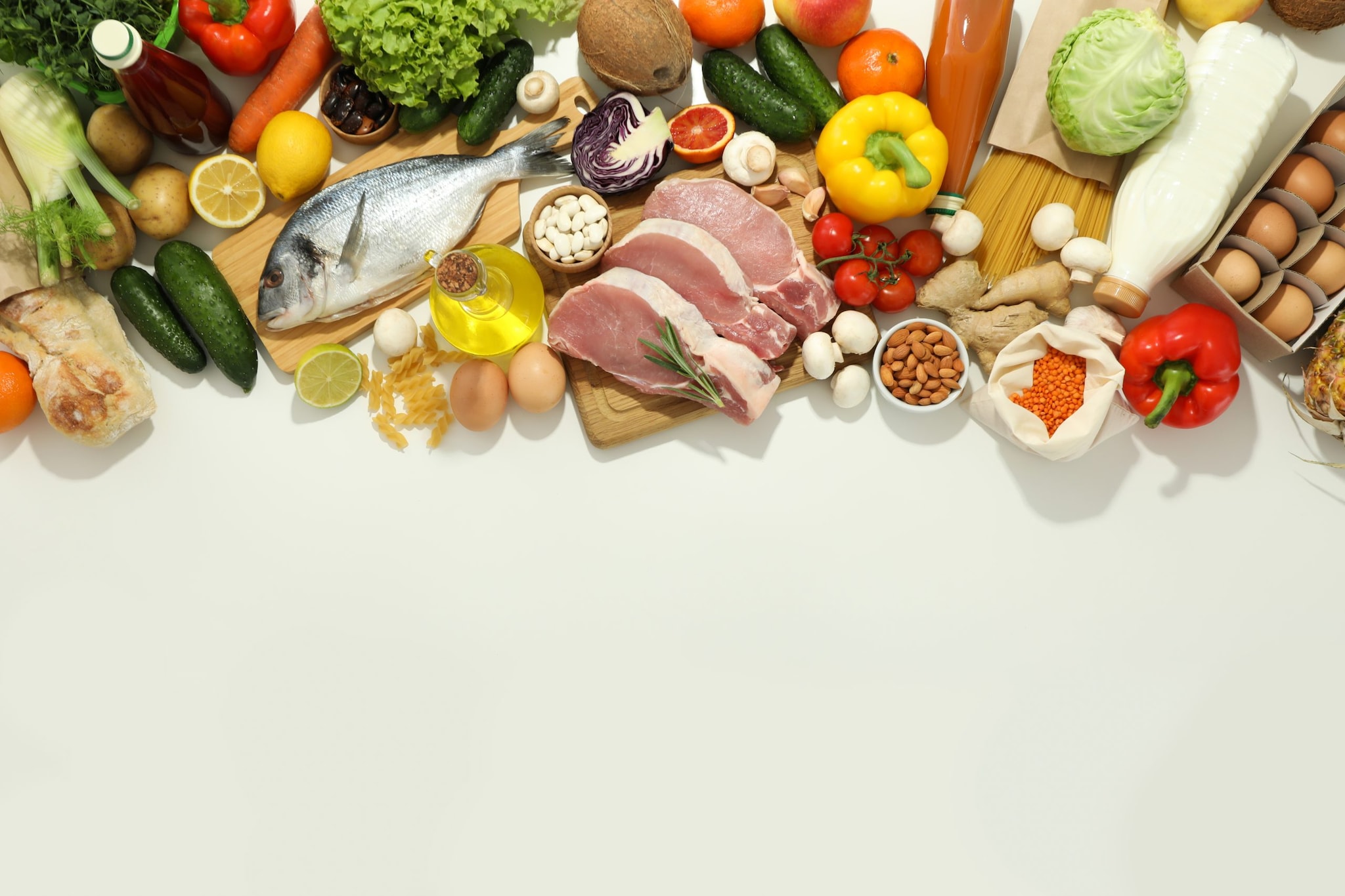 Images shows a spread of several types of foods like fruits, vegetables, fish, eggs, meats, nuts, milk, and bread.