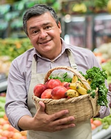 Grocery store owner with basket of vegatables