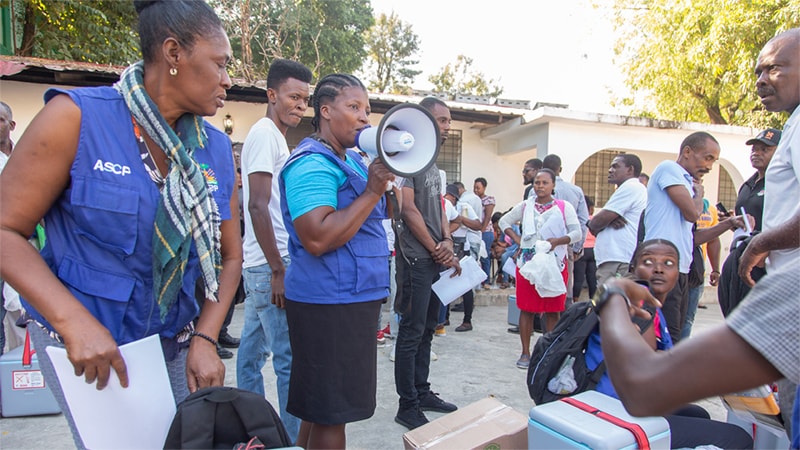 Community health workers educate residents on cholera prevention and hygiene practices.