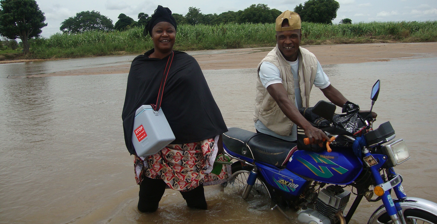 Dr. Endie Waziri (left) crossing a river in Nigeria to vaccinate children against polio. <em>Photo: NSTOP Team</em>