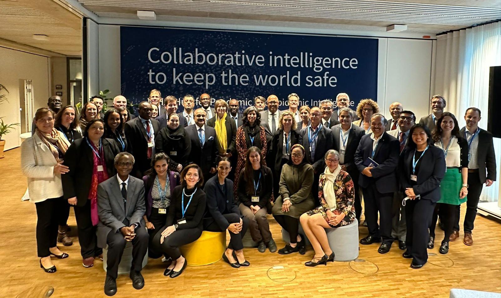 Group photo of participants in front of a sign that says collaborative intelligence to keep the world safe