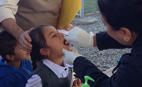 Girl receiving oral cholera vaccine in a camp for displaced Iraqis, Erbil Iraq (Source: Eugene Lam, CDC)