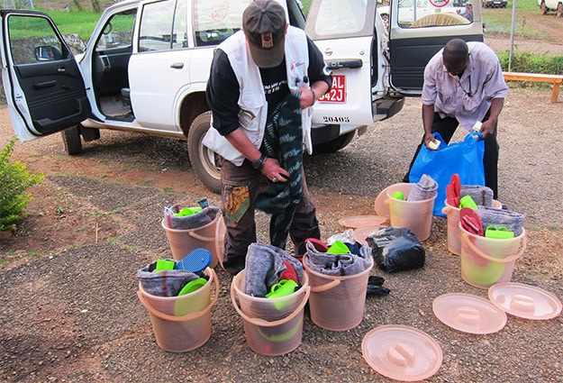 A member of Doctors Without Borders (left) and a Ugandan health worker prepare kits for Ebola survivors to take home upon discharge from the hospital.